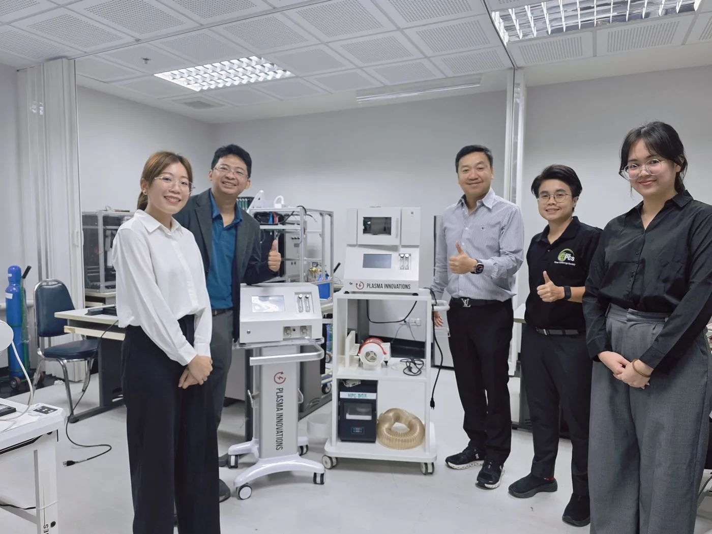 ทีม Plasma Innovations ถ่ายภาพร่วมกับเครื่องพลาสมาเย็นในห้องปฏิบัติการ